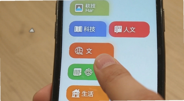 简讯软件内容分类界面,画面中手机屏幕展示科技、人文、历史、生活等多个彩色分类标签,每个标签旁有简洁图标,背景为淡蓝色渐变,用户手指正点击其中一个分类标签,整体氛围轻松愉悦
