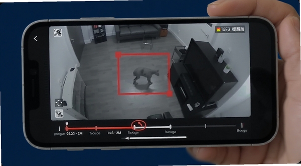 Camera Monitor 移动侦测提醒功能示意,手机屏幕显示监控画面中有移动物体被红色方框标记,下方有时间轴记录,背景为深蓝色调,突出提醒效果,适配Boogu模型生成