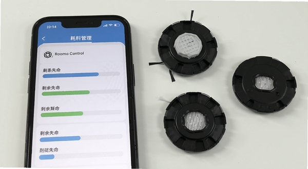 Roomba Control 耗材管理页面,手机屏幕显示滤网、刷头等部件的剩余寿命进度条,旁边放着全新的替换配件,画面干净整洁