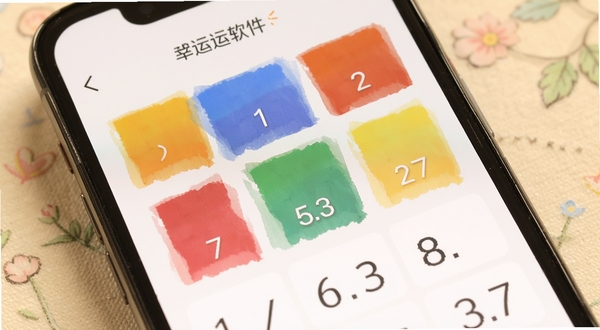 潮幸运软件中幸运色卡片与数字展示界面的特写,画面主体为手机屏幕中央的彩色色块与数字组合,背景为淡雅的浅色纹理,整体风格温暖柔和适合生活服务类应用展示