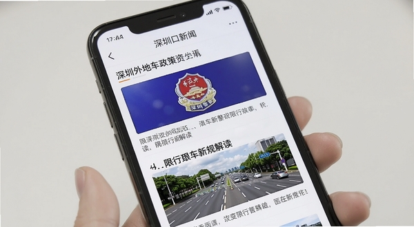 深圳外地车政策资讯界面,手机屏幕显示新闻列表,标题包含限行新规解读,配图有深圳交警标志与道路图片,整体风格正式清晰,背景为白色