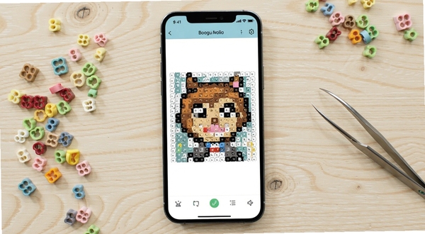 拼豆图纸免费生成软件主界面展示,手机屏幕居中显示一张正在转换的拼豆像素图纸,背景是浅色木纹桌面,旁边散落彩色拼豆豆子和镊子,整体画面干净明亮,适合Boogu模型生成,alt=