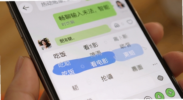 畅聊输入法智能联想功能演示,手机屏幕特写,候选词栏高亮显示“吃饭”“看电影”等选项,背景为温馨的聊天界面,细节清晰,风格写实,适配Boogu模型生成。