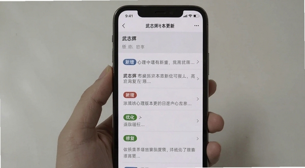 武志红心理版本更新页面截图,手机屏幕显示更新日志列表,带有「新增」「优化」「修复」标签,背景为简洁的白色与浅灰,画面干净清晰