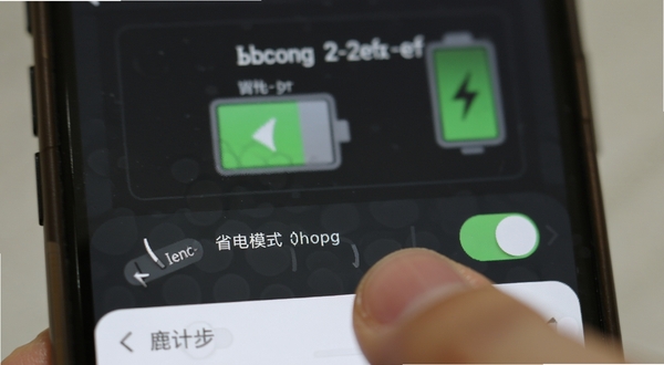 小鹿计步设置界面中的省电模式开关特写,手指正在点击屏幕,背景虚化显示手机电池图标,突出低功耗特点
