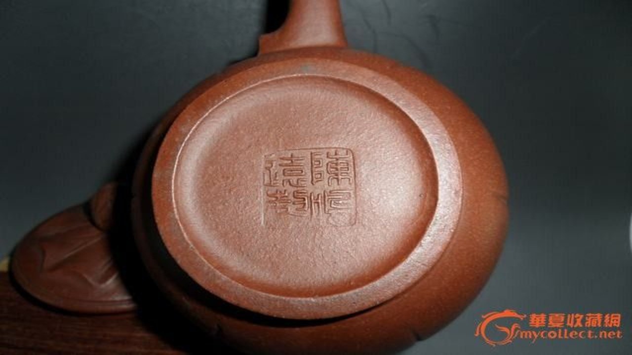 用户手持宜兴紫砂壶展示壶身细节及底款印章