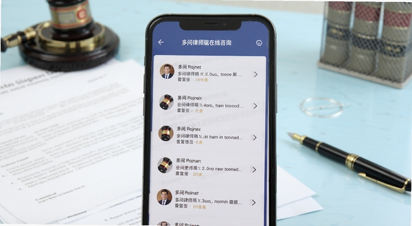 多问律师端在线咨询界面,手机屏幕显示多条律师回复列表,画面主体为手机居中放置,背景为柔和的浅蓝色办公桌面,桌面上有法律文书与签字笔,整体氛围专业严谨,突出即时沟通的便捷感