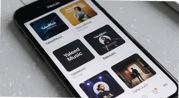 YaleedMusic 播放列表管理界面特写,手机屏幕显示多个自建歌单卡片,卡片带有自定义封面缩略图,背景为柔和浅灰质感桌面,画面干净利落,体现软件本地化管理特色
