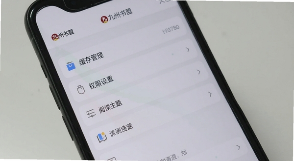 手机屏幕显示九州书盟设置界面,包含缓存管理、权限设置、阅读主题等选项,界面布局清晰,背景为浅灰色极简风格,突出功能设置便捷性,画面中有九州书盟字样