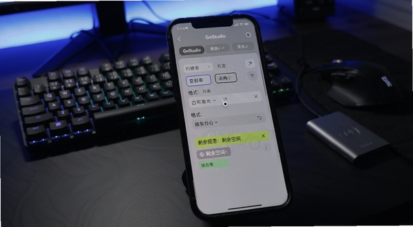 GoStudio 导出设置与存储空间检查界面,手机屏幕显示导出参数面板,包含分辨率选项、格式选择与剩余空间提示条,背景为深色桌面搭配键盘与移动硬盘,画面带有科技感的冷色调灯光,突出导出前的准备环节