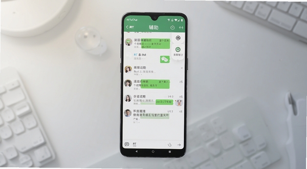 RT WeChat 应用主界面展示,画面中央为手机屏幕特写,屏幕内呈现简洁的会话列表与消息管理面板,背景为浅灰色渐变的工作台环境,柔和光线从左上角打来,整体风格干净清爽,突出安卓通讯辅助工具的产品全貌