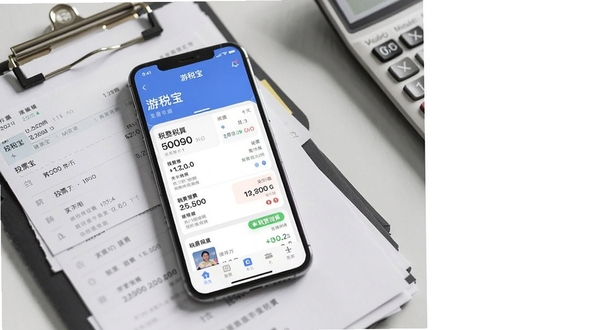 画面中央偏左位置放置一部智能手机,屏幕显示游税宝应用主界面,包含发票列表与税费测算卡片,背景区域为浅灰色办公桌面,散落票据夹与计算器,右上角留白,整体风格简洁商务,光线柔和,适合下载站配图使用