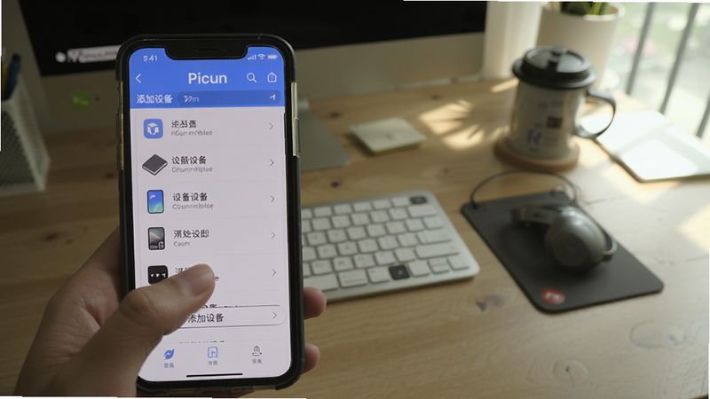 展示手机操作Picun的步骤截图,手指点击“添加设备”,屏幕显示设备列表,背景为真实桌面场景,光线自然