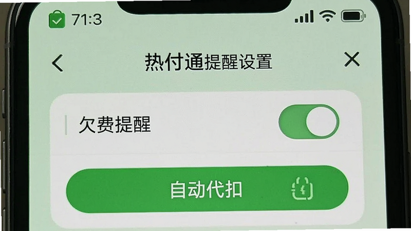 热付通提醒设置页面,显示“欠费提醒”开关和“自动代扣”开通按钮,背景为浅绿色,手机顶部有通知栏图标,模拟真实手机界面。