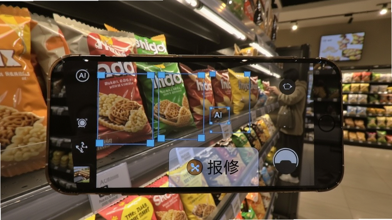 手机拍摄零食货架陈列的画面,屏幕上有AI识别框标注商品排列问题,旁边有报修按钮,背景是店内,灯光柔和,真实感强