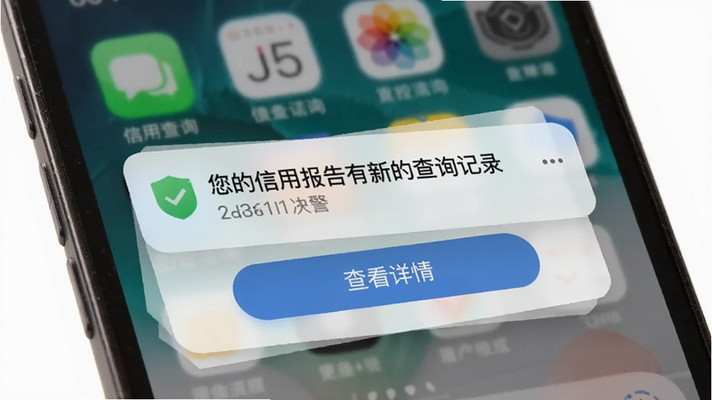信用查询APP的监控预警界面,手机屏幕上显示一条推送通知,内容为“您的信用报告有新的查询记录”,底部有查看详情按钮,背景为手机桌面风格。