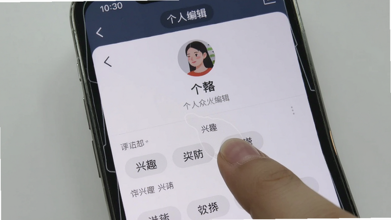 啥时约移动端操作界面截图,手机屏幕显示个人资料编辑页面,手指点击兴趣标签,背景为浅灰色,突出操作步骤