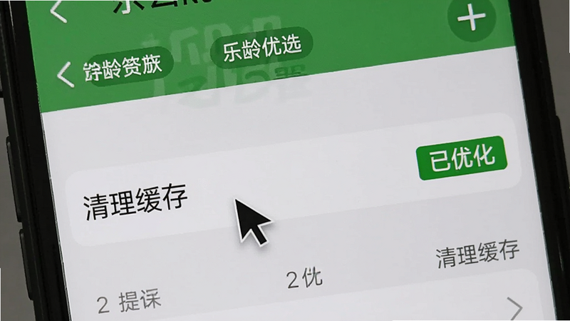 手机屏幕上显示乐龄优选的设置页面,光标指向“清理缓存”选项,背景为系统设置界面,旁边有“已优化”绿色标识。
