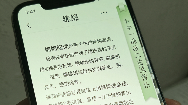 手机屏幕上展示绵绵阅读界面,左侧是细腻的文字排版,右侧是滚动书签,背景为淡绿色护眼模式,文字清晰,突出软件名称“绵绵”和阅读舒适度