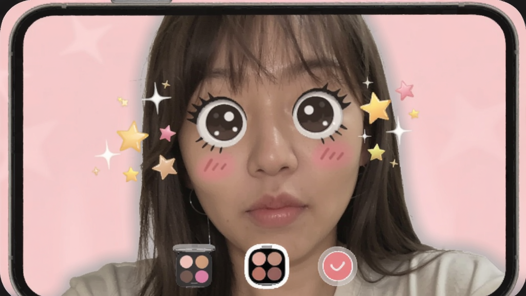 A selfie preview on phone screen with a cute face filter overlay, stars and sparkles around the face, makeup palette icons at bottom, pastel pink background, Boogu model.