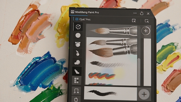 MediBang Paint Pro笔刷选择面板特写,展示多种形状的画笔图标与笔触效果预览,画布上呈现不同颜色的油彩笔触,光线柔和,突出软件丰富的笔刷库
