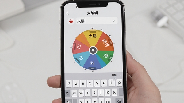 大转盘就决定自定义编辑界面预览图,手机屏幕上显示转盘选项编辑页面,用户正在输入“火锅”、“烧烤”、“日料”等文字,键盘弹出,背景为浅灰色,界面简洁清晰,突出自定义功能的灵活性和便捷性