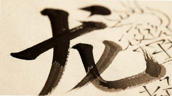 华文行楷字体细节特写,画面聚焦在单个“龙”字的笔画上,展示起笔、运笔和收笔的墨迹变化,笔锋犀利,墨色由浓到淡自然过渡,背景为米黄色仿古纸,光线柔和,突出书法笔触的立体感和艺术张力。