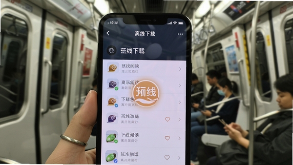 蜗牛阅读离线下载界面,手机屏幕显示下载管理列表,背景为地铁车厢场景,突出离线阅读标识,画面现代都市感,色调自然