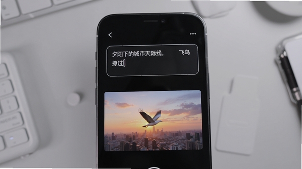 快映AI文字生成视频功能演示,手机屏幕中显示输入框“夕阳下的城市天际线,飞鸟掠过”,下方生成对应动态视频预览,画面色彩丰富,光影柔和,背景为浅灰色工作台,突出AI生成效果