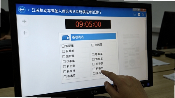江苏机动车驾驶人理论考试系统模拟考试进行中的截图,屏幕上有倒计时提示和答题卡,鼠标正在点击选项,画面模拟真实考试场景,风格写实