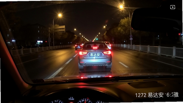 易达安记录仪夜间行车录像画面,高清画质,清晰显示前方车辆车牌,道路灯光反射,画面真实细腻,体现夜视效果。