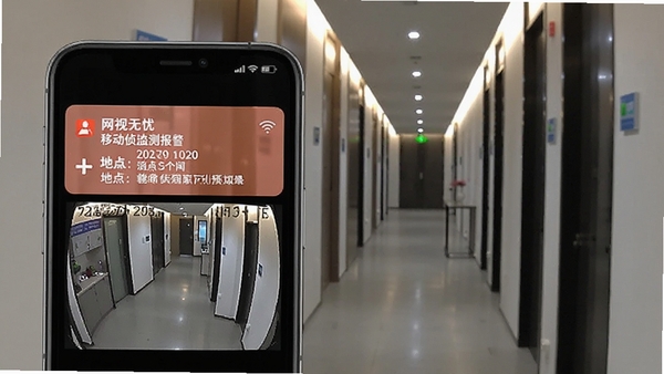 网视无忧移动侦测报警功能预览图,手机屏幕展示一条报警通知消息,附带事件抓拍画面,背景为室内走廊场景,报警时间与地点信息清晰可见