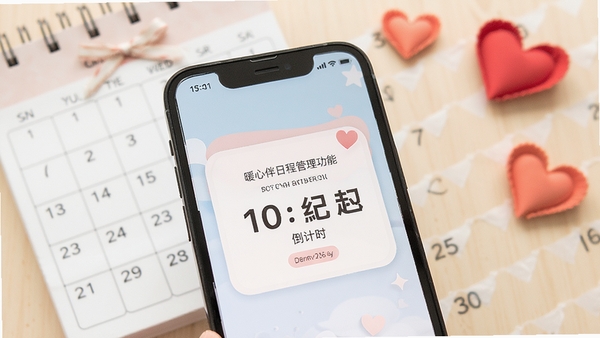 暖心伴日程管理功能展示,手机屏幕上显示纪念日倒计时卡片,背景有日历和爱心装饰,整体色彩柔和,画面清晰