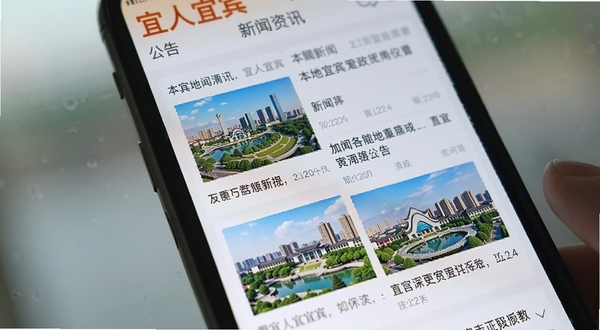宜人宜宾 新闻资讯页面特写 手机屏幕显示本地新闻列表与政务公告 标题醒目 配图为城市风光 整体色调清爽 背景虚化处理 突出应用界面细节