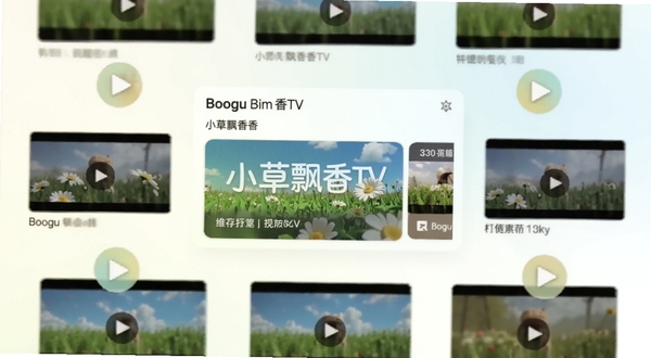 小草飘香香TV 软件主界面展示,画面中央为软件首页推荐卡片区域,背景为浅色渐变,周围环绕播放按钮与视频缩略图,整体风格简洁清爽,适合Boogu模型生成
