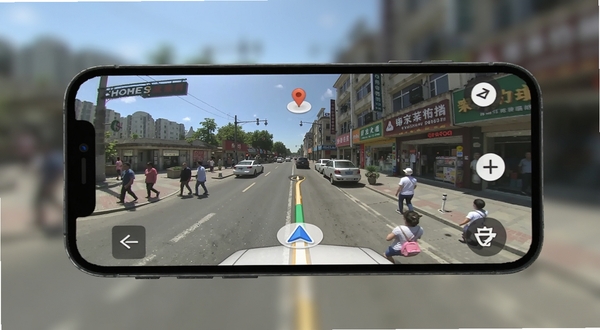 即刻全景卫星导航全景街景功能展示 手机屏幕中显示街道实景与地图定位图标 行人车辆 商铺招牌 白天光线充足