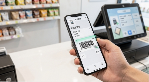 茸店管家商品管理界面特写,画面主体为一只手拿着手机扫描商品条形码,手机屏幕显示商品名称、价格和库存数量正在自动填充,背景是整洁的店铺收银台,画面明亮清晰,突出便捷高效的科技感