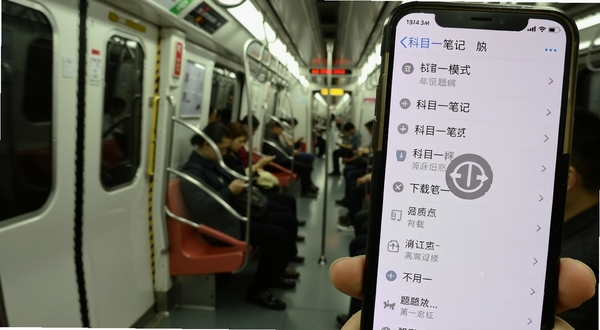 科目一笔记 离线学习模式界面 手机屏幕显示已下载题库列表 灰色离线图标 背景为地铁车厢 画面生活化 通勤场景