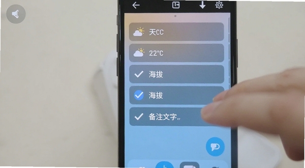 时间地点水印相机自定义水印设置界面,手机屏幕展示多个可勾选的水印选项,包括天气、温度、海拔、备注文字,界面风格清爽,背景为浅色渐变,手指正在点击勾选框
