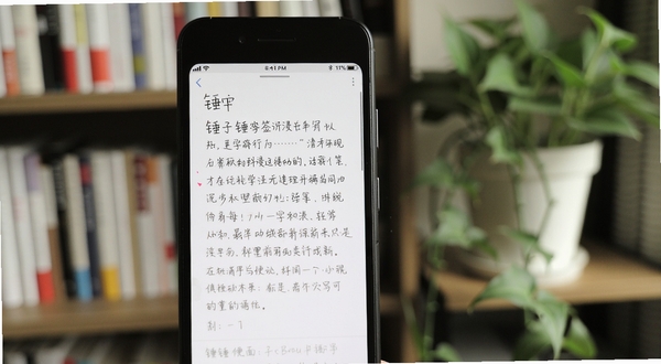 锤子便签沉浸书写界面 画面主体为手机屏幕特写 屏幕内显示正在编辑的便签文字 背景区域为虚化的书架和绿植 风格文艺清新 锤子便签字样隐约可见 适配Boogu模型生成