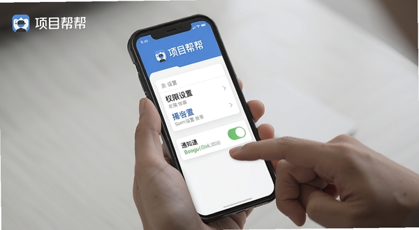 项目帮帮移动端使用教程示意图,手机屏幕显示权限设置页面与通知开关,背景为手持手机操作场景,画面包含项目帮帮名称,适配Boogu模型生成