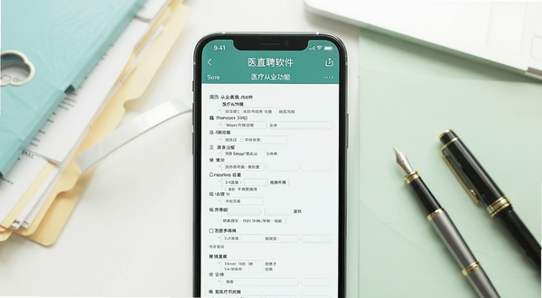 医直聘软件内简历投递功能界面展示,画面主体为手机屏幕显示简历编辑页面,屏幕中央有填写完整的医疗从业者简历信息,背景区域为白色与淡绿色交织的办公桌面环境,点缀文件夹和钢笔元素,整体风格清新商务