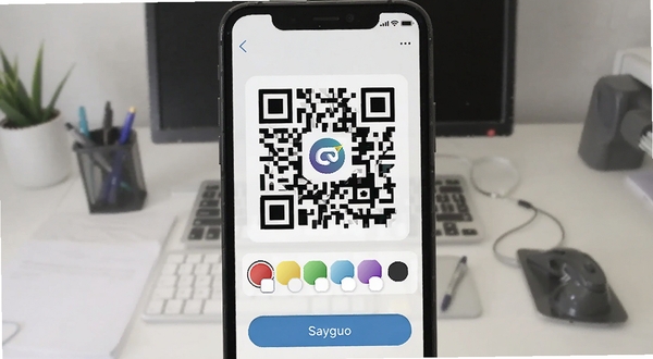 二维码与条形码软件生成功能界面,手机屏幕上显示一个带有中心Logo的彩色二维码,下方有颜色选择器和保存按钮,背景为办公桌面,适配Boogu模型生成