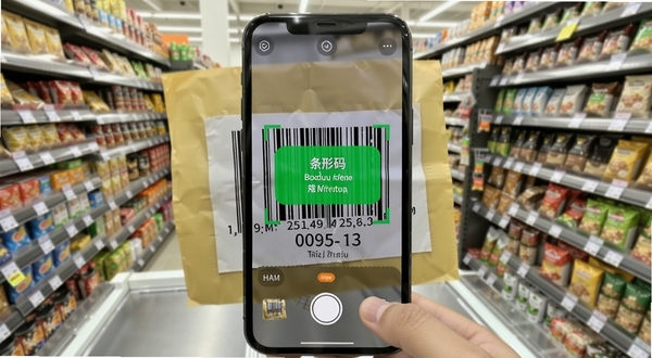 二维码与条形码软件扫描识别功能展示,手机镜头对准一张商品条形码,屏幕内出现识别成功的绿色提示框与结果文字,背景为超市货架场景,画面明亮清晰,适配Boogu模型生成
