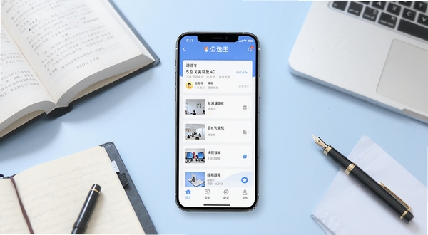 公选王遴选手机应用主界面展示,画面中央放置一部竖屏智能手机,屏幕内呈现遴选备考APP的课程列表与题库入口,手机周围环绕书籍、笔记本与钢笔等学习元素,背景为浅蓝色渐变办公桌面,整体风格简洁专业,适合Boogu模型生成