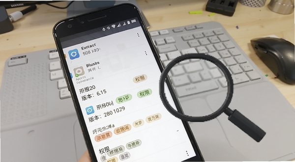 开发助手应用详情页面截图,画面展示安卓手机屏幕上列出的应用包名、版本号与权限标签,旁边有放大镜图标指向权限列表,背景为浅灰色工作台,整体呈现工程师桌面场景,突出信息查看的便捷性