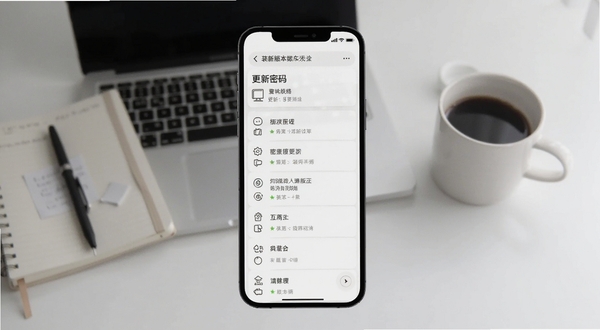 装修密码最新版本更新界面截图,手机屏幕显示更新日志列表,背景为简洁的书桌场景,有笔记本和咖啡杯,画面干净,突出版本迭代的细节