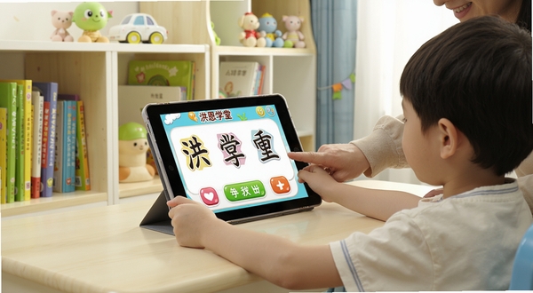 洪恩学堂在平板电脑上的学习场景,画面展示一个孩子坐在书桌前使用平板学习识字课程,屏幕上显示卡通汉字和互动按钮,旁边有家长陪伴指导,背景为明亮整洁的儿童书房