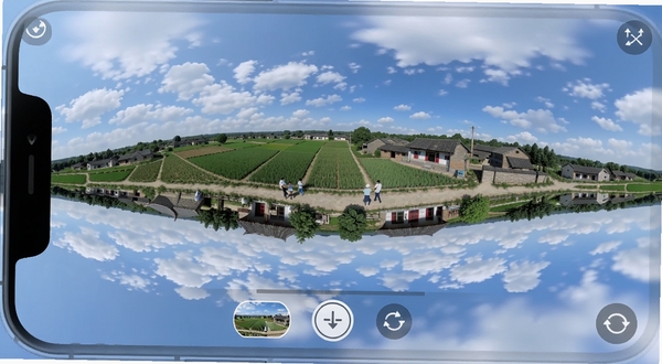 VR全景家乡 手机端全景浏览界面 画面中央展示一个360度可旋转的乡村全景视图 背景是蓝天白云下的田野与村落 界面底部有场景切换按钮和视角复位图标 整体风格清新自然 适配Boogu模型生成