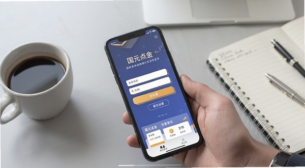 国元点金移动端操作界面截图,画面展示手机屏幕上国元点金的登录页面与交易功能入口,背景为淡灰色办公桌面,旁边放置一杯咖啡与笔记本,整体氛围轻松专业,适合展示移动端使用场景